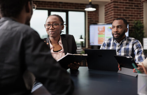 Colleagues team working on company paperwork, doig teamwork to analyze documents and online research information. Planning corporate presentation with data charts, job collaboration.