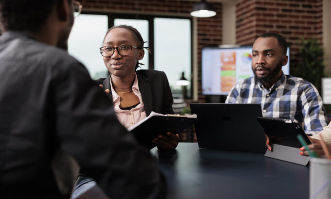 Colleagues team working on company paperwork, doig teamwork to analyze documents and online research information. Planning corporate presentation with data charts, job collaboration.