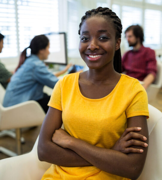 Female graphic designer sitting with arms crossed in office